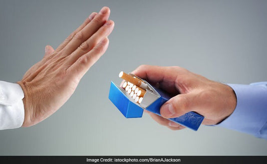 A hand holding a packet of cigarettes